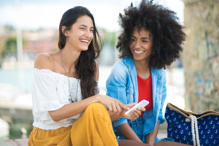 Two woman using mobile phone.