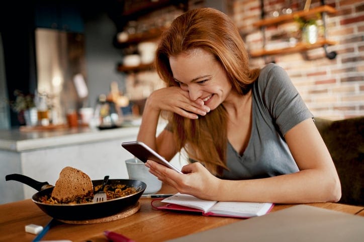 Woman looking at a text and laughing