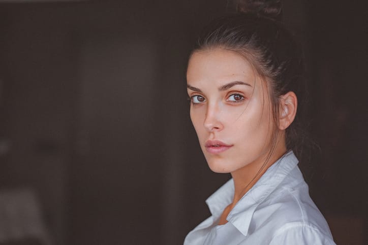 Portrait of a pensive young woman in white shirt