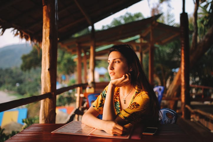 Young woman relaxing in the beach bar on the island of Koh Lanta, Thailand