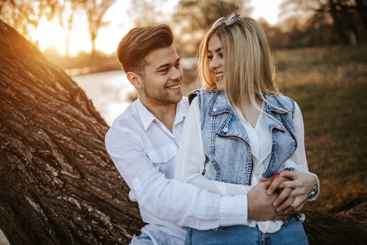 Happy young couple embracing by the river