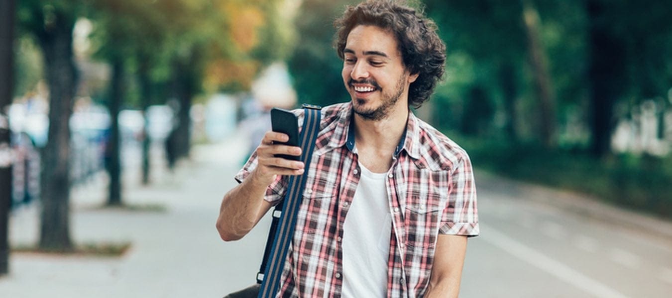 curly haired man texting