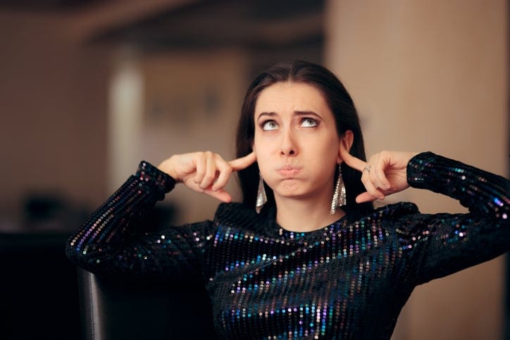 Woman plugging her ears.
