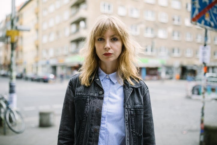 young blonde woman standing in the street