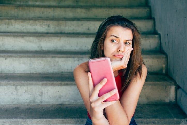 Woman sitting alone on stairs.