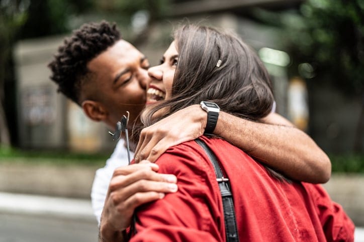 happy guy kissing girl on cheek