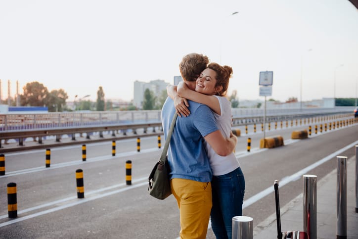 Couple hugging at the airport.