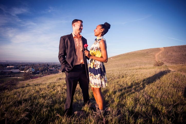 man and woman standing in a field being romantic