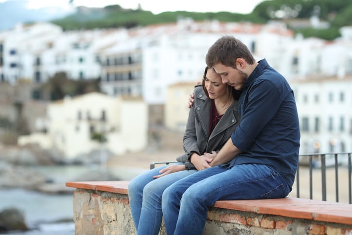 couple consoling each other on a wall
