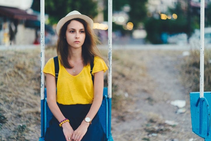 sad girl sat on a swing