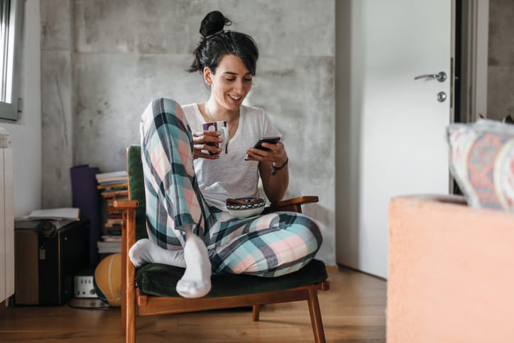 woman sitting on a chair texting