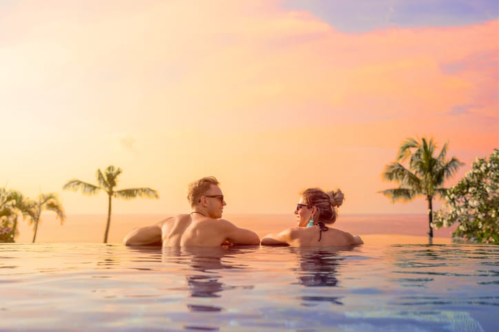 Sunset couple in an infinity pool.