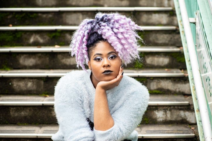 Outdoor portrait of a young woman with purple coloured hair