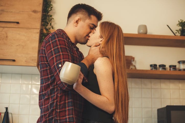 couple kissing in the kitchen