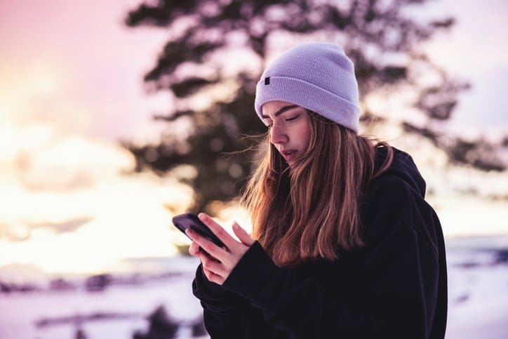 sad woman texting in winter