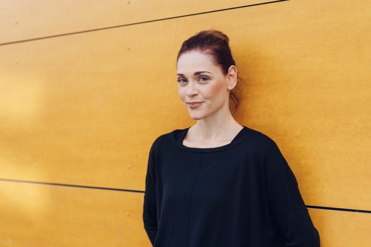 woman standing against a yellow wall