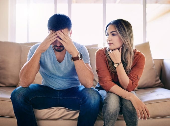 unhappy young couple sitting on safe arguing or about to break up