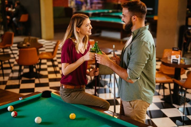 couple playing pool at bar date