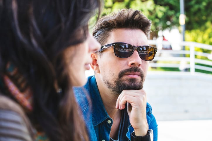 man with glasses arguing with woman