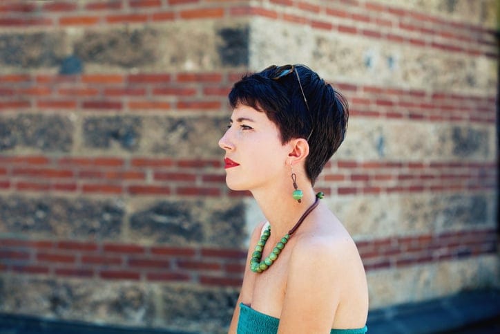 short haired woman outside near wall
