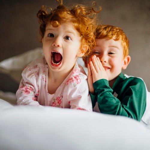 Two young children laughing together.