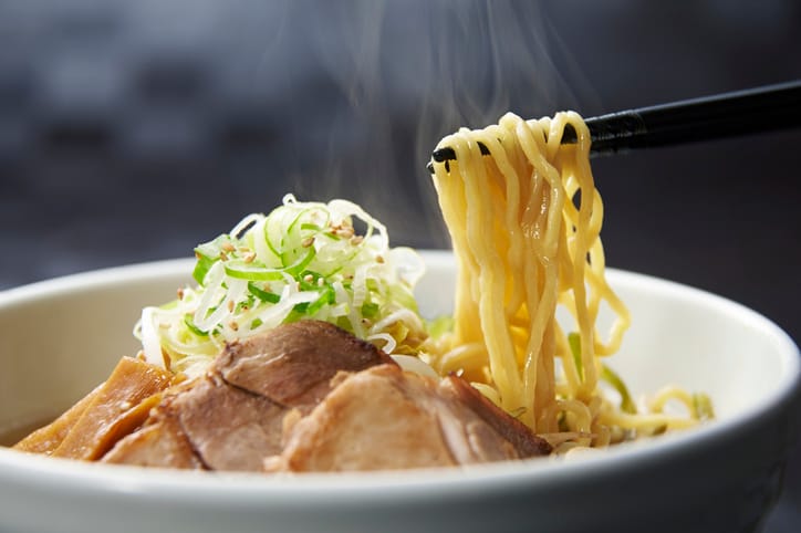Eating Ramen noodles with chopsticks.