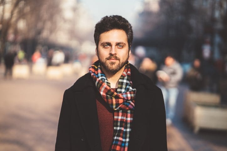 man with bear and check scarf in street