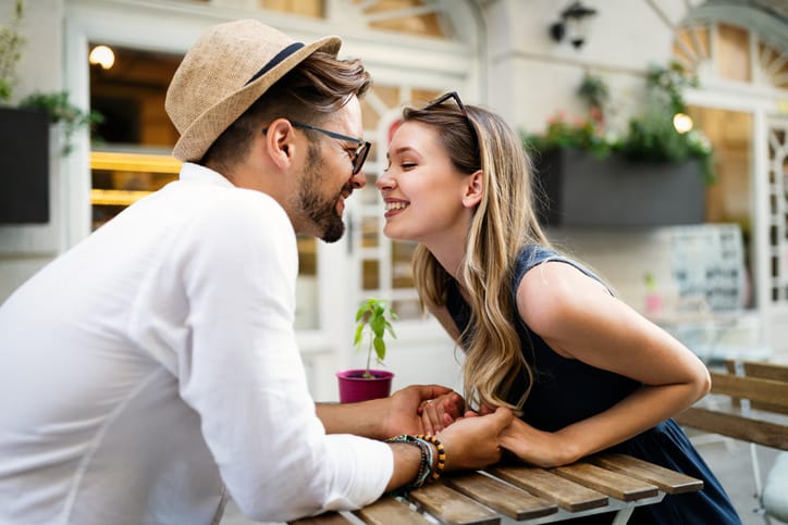 couple nose to nose about to kiss over a table