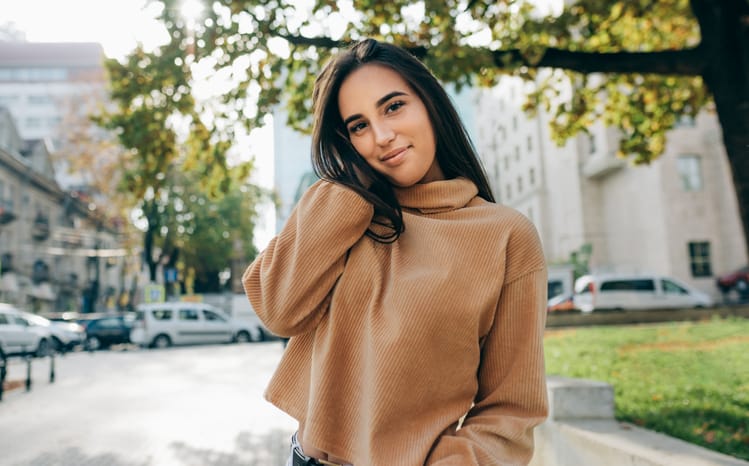 brunette in brown sweater smiling