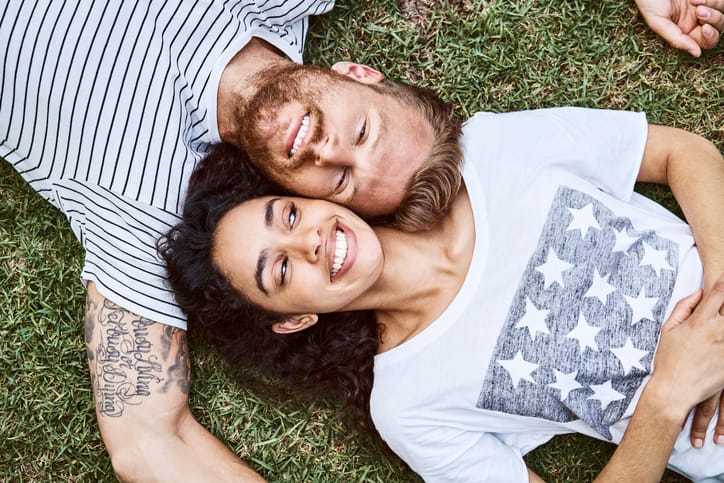 two people laying on the ground smiling