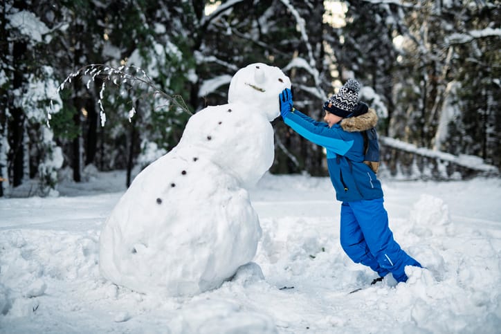 Little boy building a snowman on a winter's day