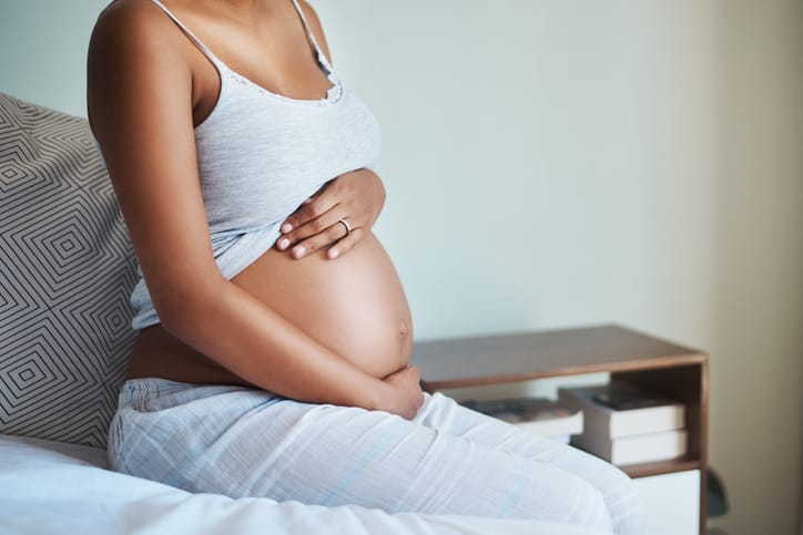 Pregnant woman on her bed.