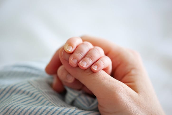 mom holding baby hand