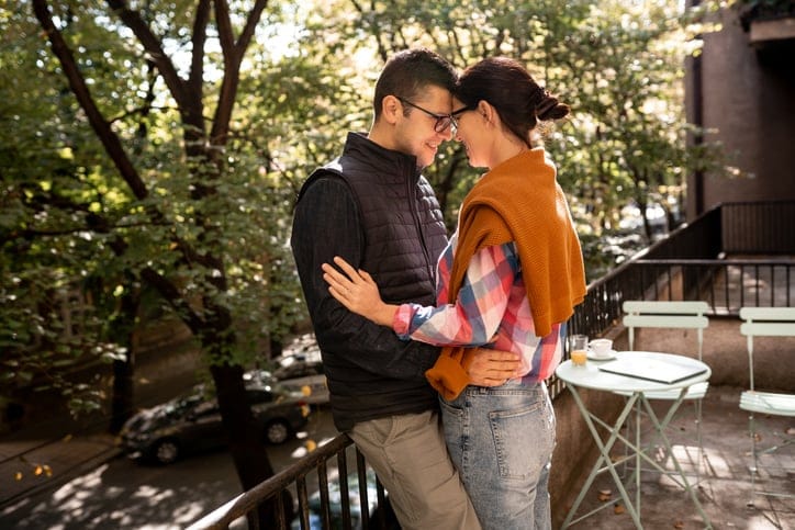 young couple kissing on a terrace