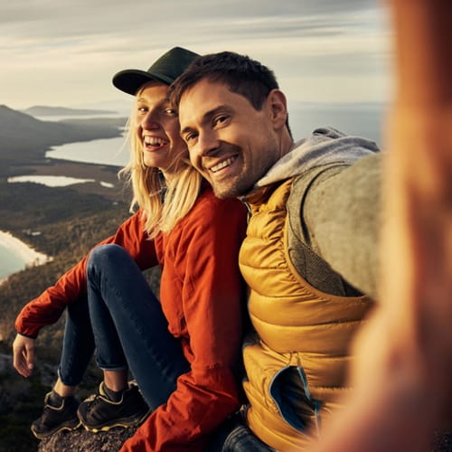 A couple talking a vacation selfie.