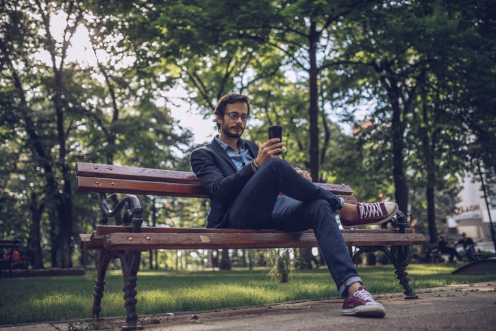 man outside park texting
