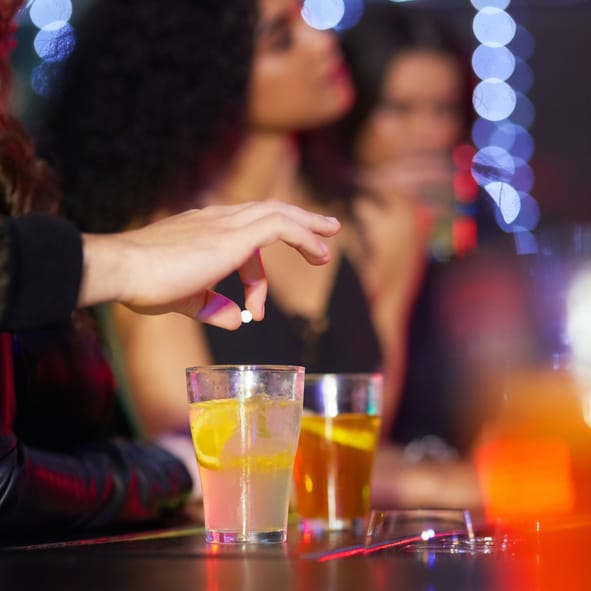mysterious hand spiking a drink