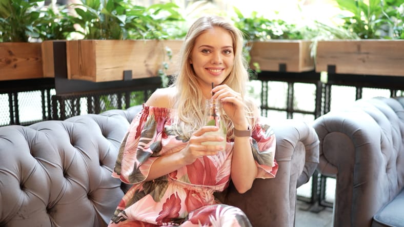 woman sitting sipping on a drink