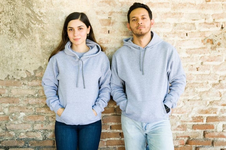 serious couple leaning against wall