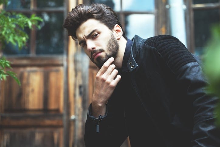 man with beard holding chin