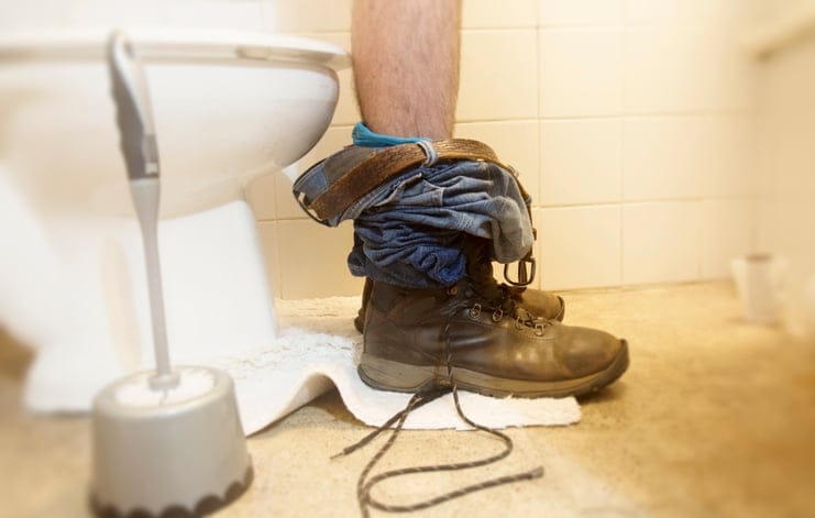 cropped shot of legs on toilet