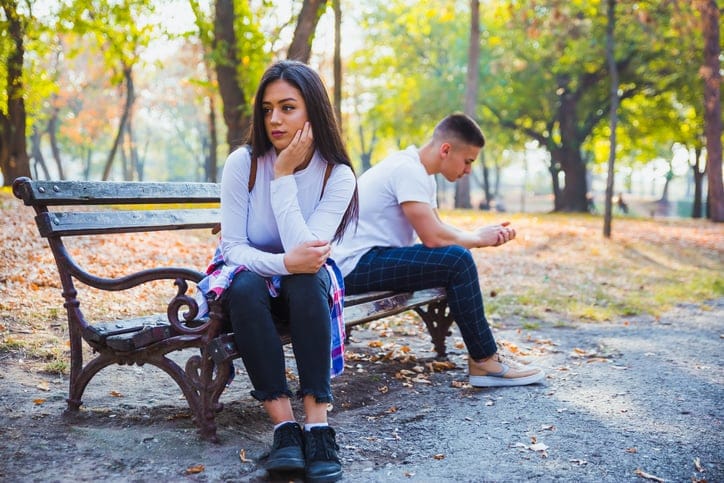 couple arguing outside bench