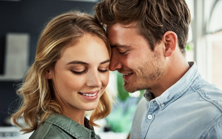 An affectionate young couple relaxing at home.