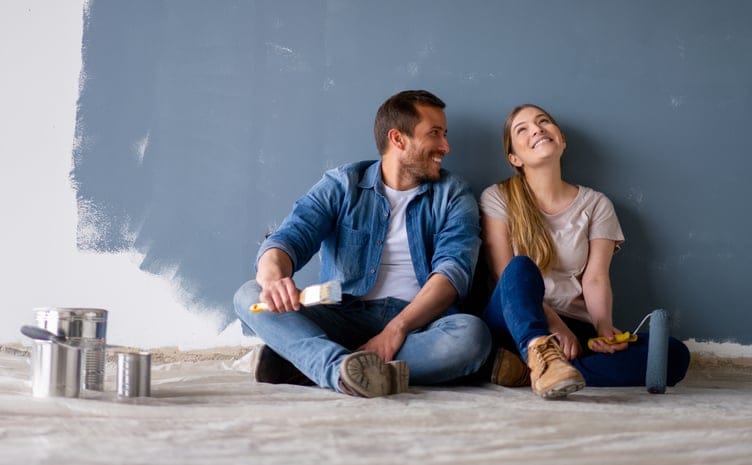 Loving couple painting the walls.