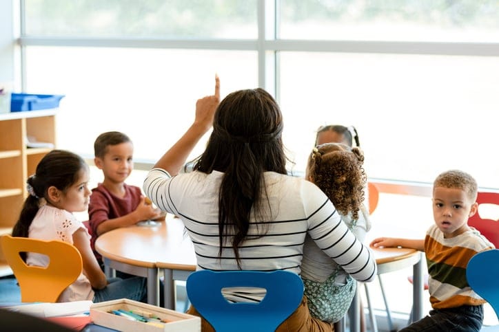 Children and their teacher in the classroom.