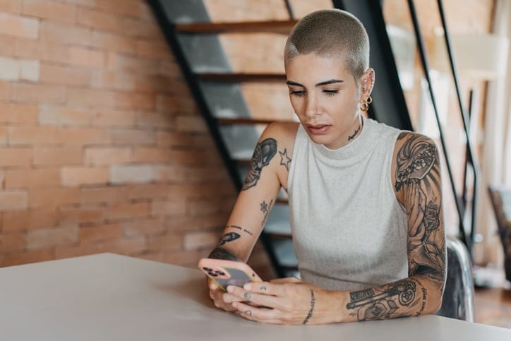 hipster woman texting at table