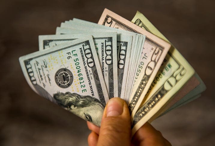 Unrecognizable mature man holding US Dollar bills. High angle view. Horizontal composition. Image taken with Nikon D800 and developed from RAW format.