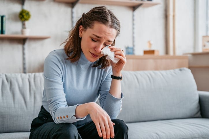 crying woman sitting on couch
