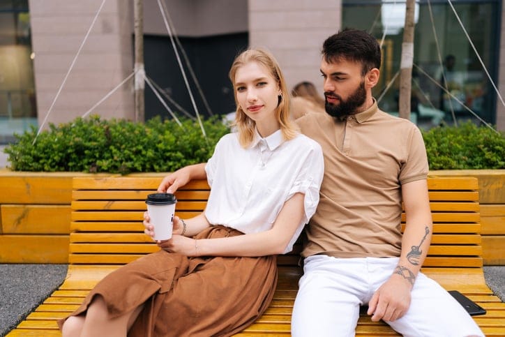 unhappy couple sitting out on park bench