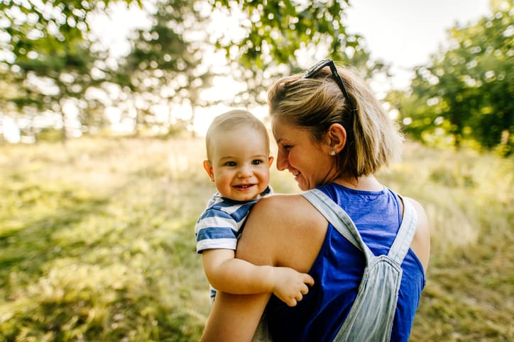 Photo of baby boy and his mom in nature.
